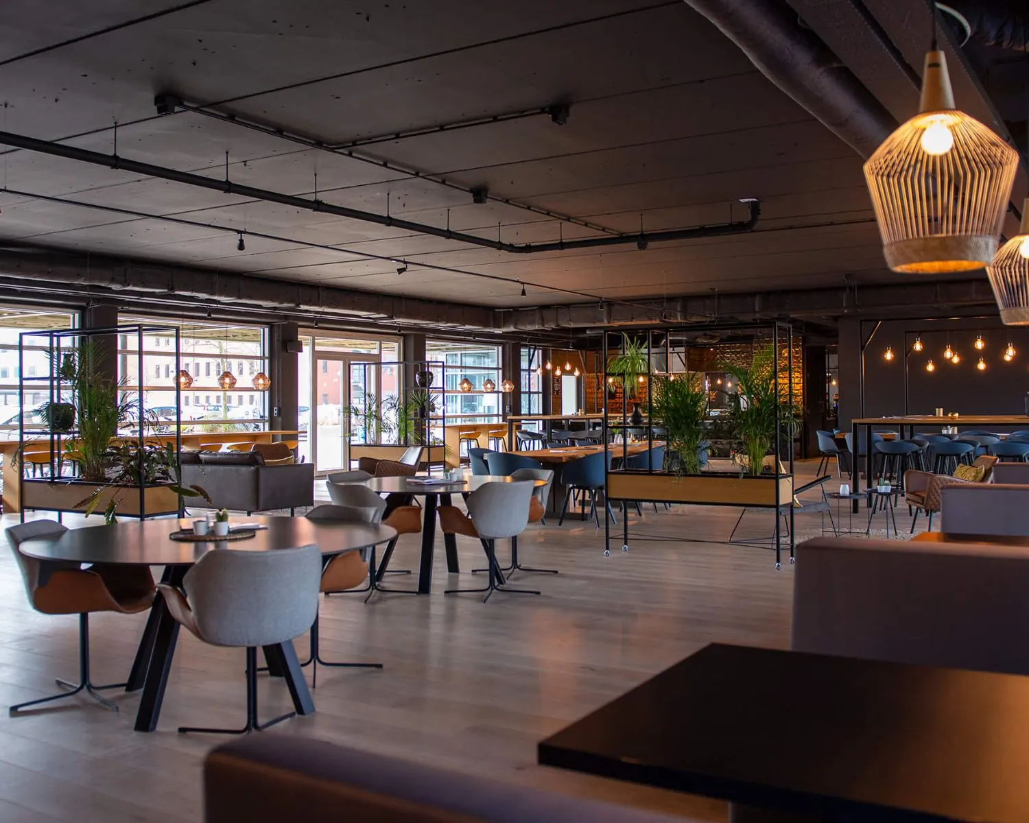 Modern ingerichte horecaruimte in het Stadspark van Groningen met veel lichtinval, planten en zitplaatsen.