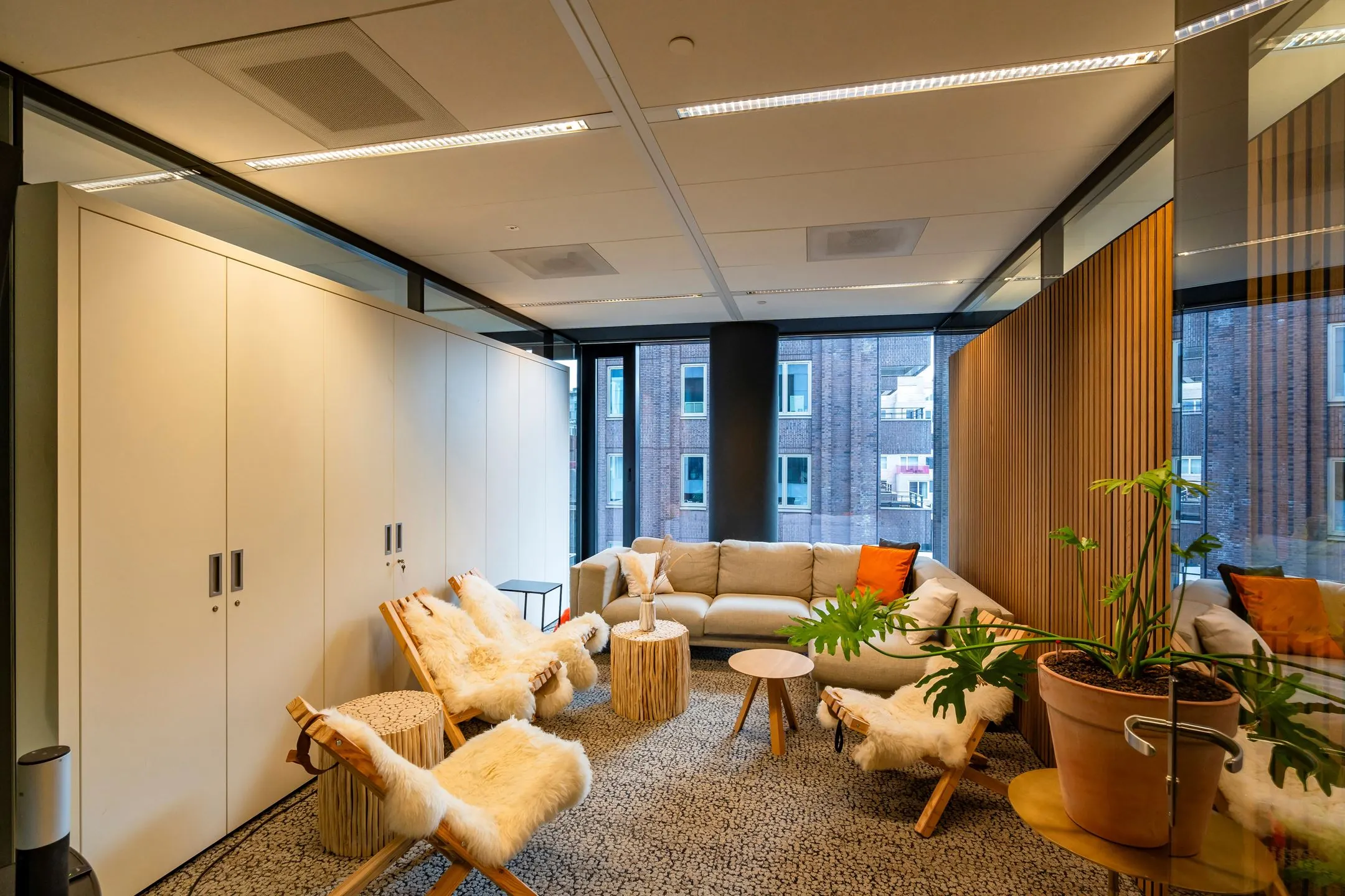 Moderne loungehoek aan de Gustav Mahlerlaan 1025 met comfortabele zitplekken, houten accenten en grote ramen.