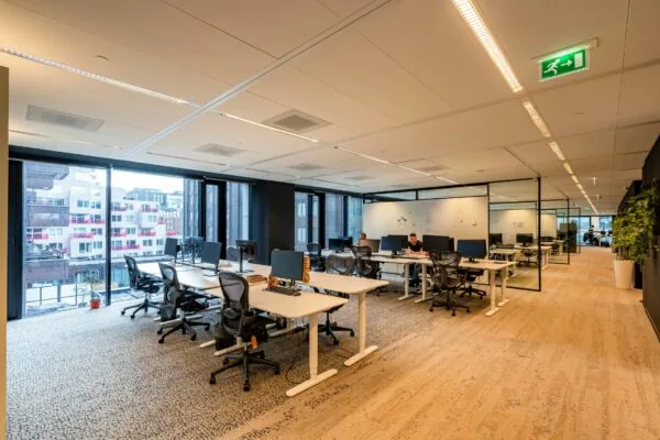 Moderne en ruime kantooretage aan de Gustav Mahlerlaan 1025 met werkplekken, glazen vergaderruimtes en uitzicht op omliggende gebouwen.