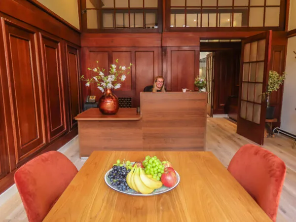 Receptie met houten interieur en een schaal vers fruit op tafel bij Herengracht 449.