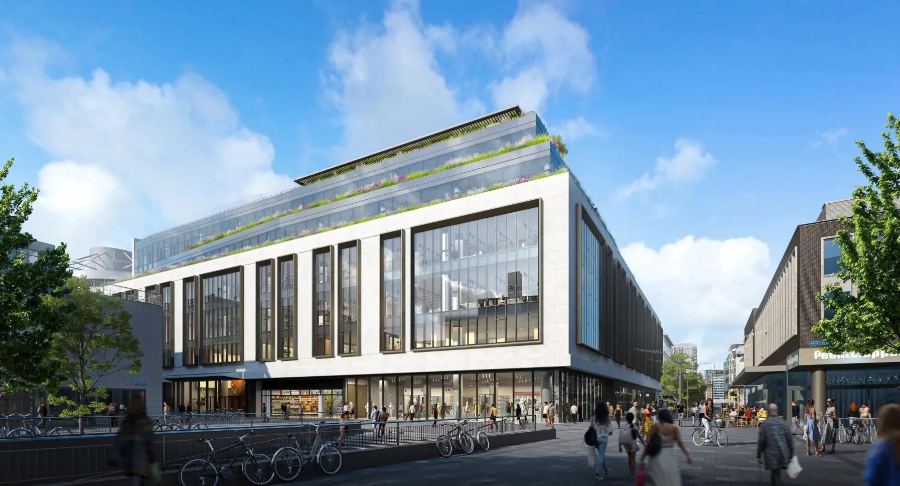 Modern kantoorgebouw aan de Hoogstraat 1001 met glazen gevel en groene terrassen, omringd door voetgangers en fietsers.