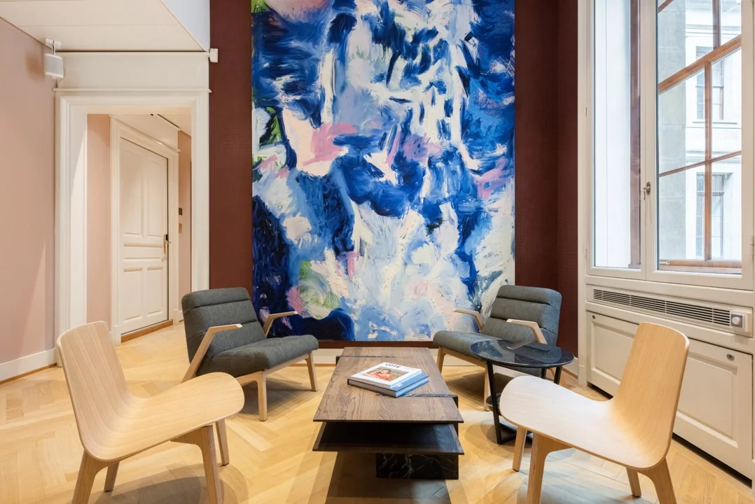 Moderne zithoek in Hoogstraat 1001 met een grote abstracte blauw-paarse muurschildering en designmeubilair.