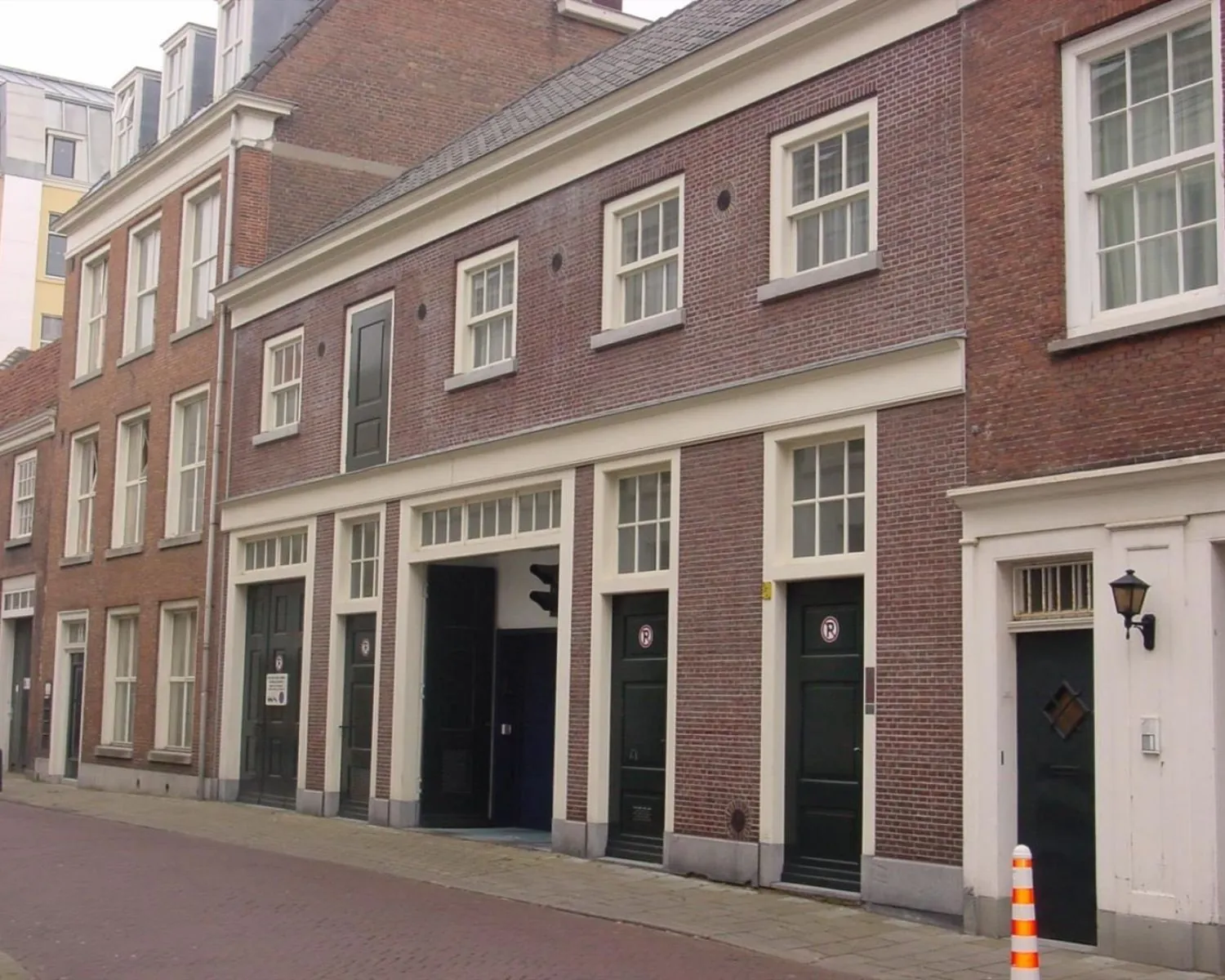 Vooraanzicht van een historisch bakstenen gebouw met meerdere deuren aan de Kazernestraat.