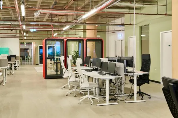 Moderne kantoorruimte aan de Johan Huizingalaan 763a met open werkplekken, bureaustoelen en afgesloten belcabines.