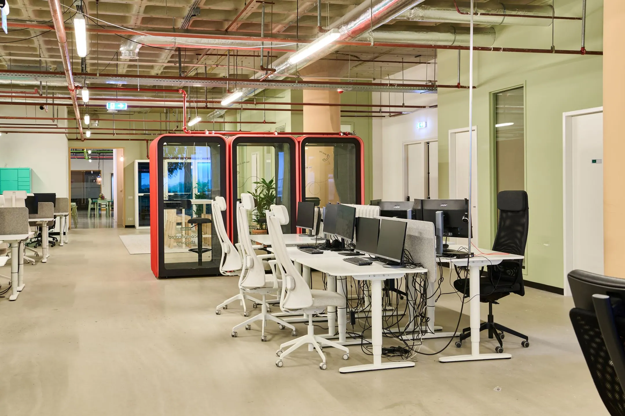 Moderne kantoorruimte aan de Johan Huizingalaan 763a met open werkplekken, bureaustoelen en afgesloten belcabines.