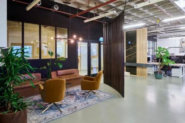 Moderne kantoorruimte aan de Johan Huizingalaan 763a met een stijlvolle zithoek, planten en open werkplekken.