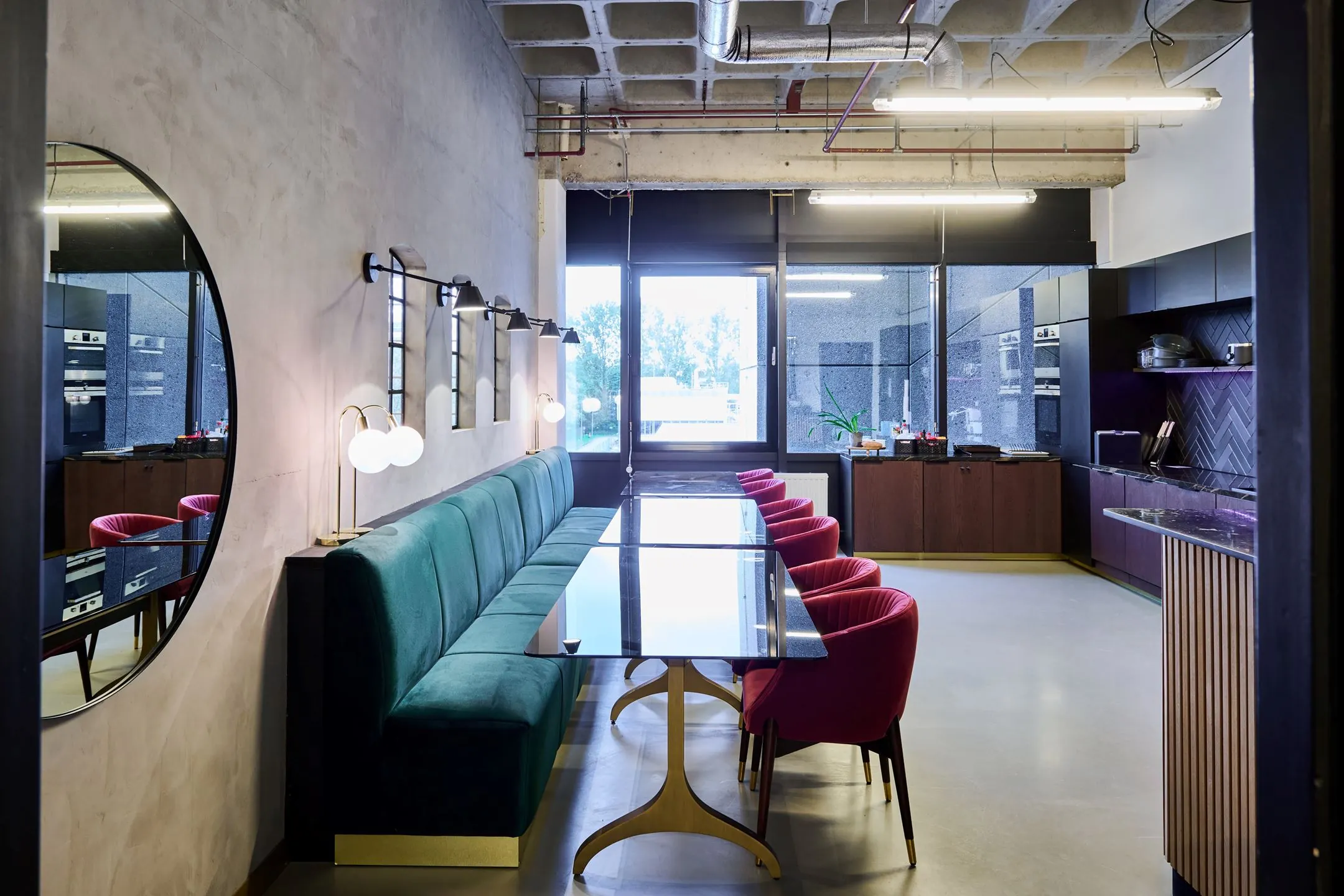 Moderne keuken en eetruimte in Johan Huizingalaan 763a met groen fluwelen bank, roze stoelen en strakke afwerking.