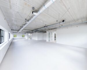 Lichte, lege kantoorruimte met grote ramen en industriële plafondafwerking aan de Basicweg 12 in Amersfoort.