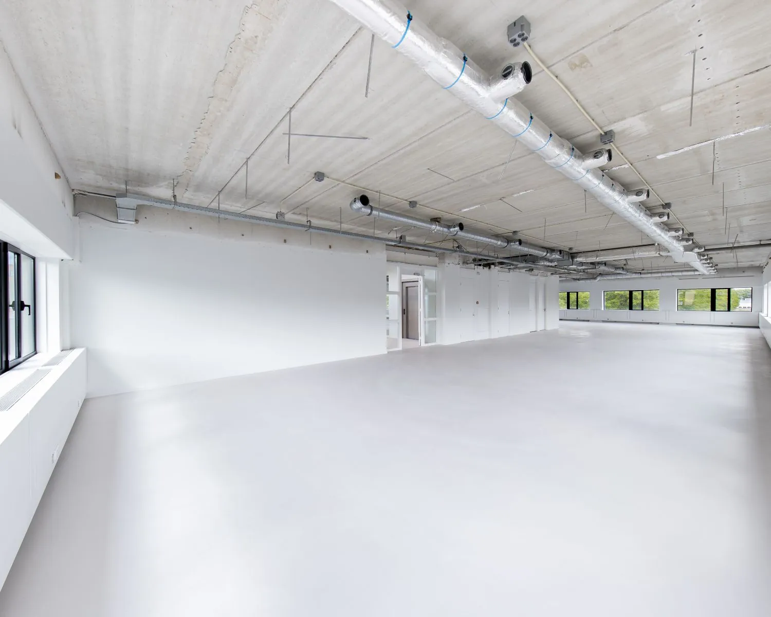 Ruime, lichte en moderne kantoorruimte te huur aan de Basicweg 12 in Amersfoort met zichtbare plafondinstallaties.