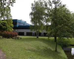 Kantoorruimte aan de Bijlmerstraat 30-32 met een groene tuin en vijver op de voorgrond.