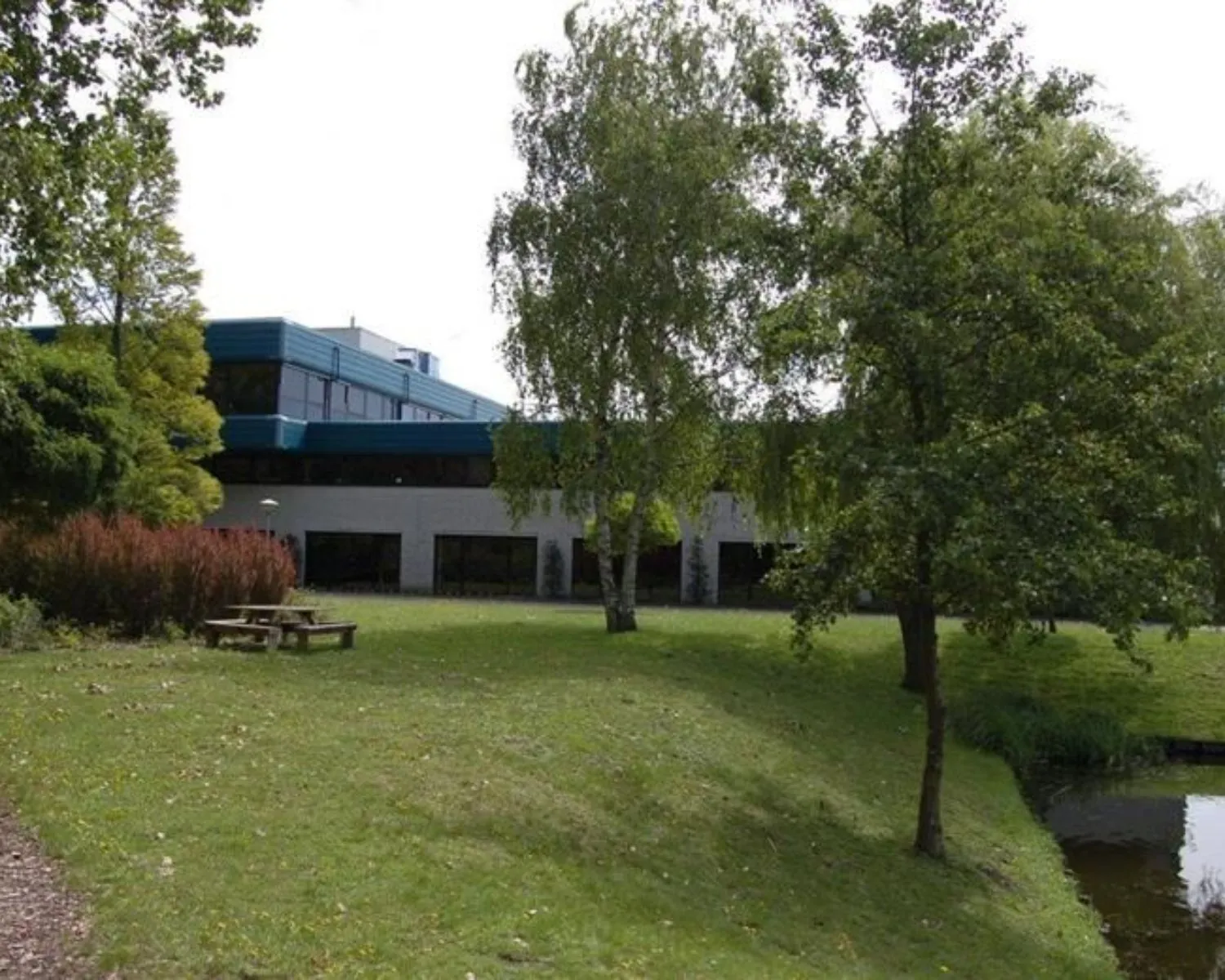 Kantoorruimte aan de Bijlmerstraat 30-32 met een groene tuin en vijver op de voorgrond.