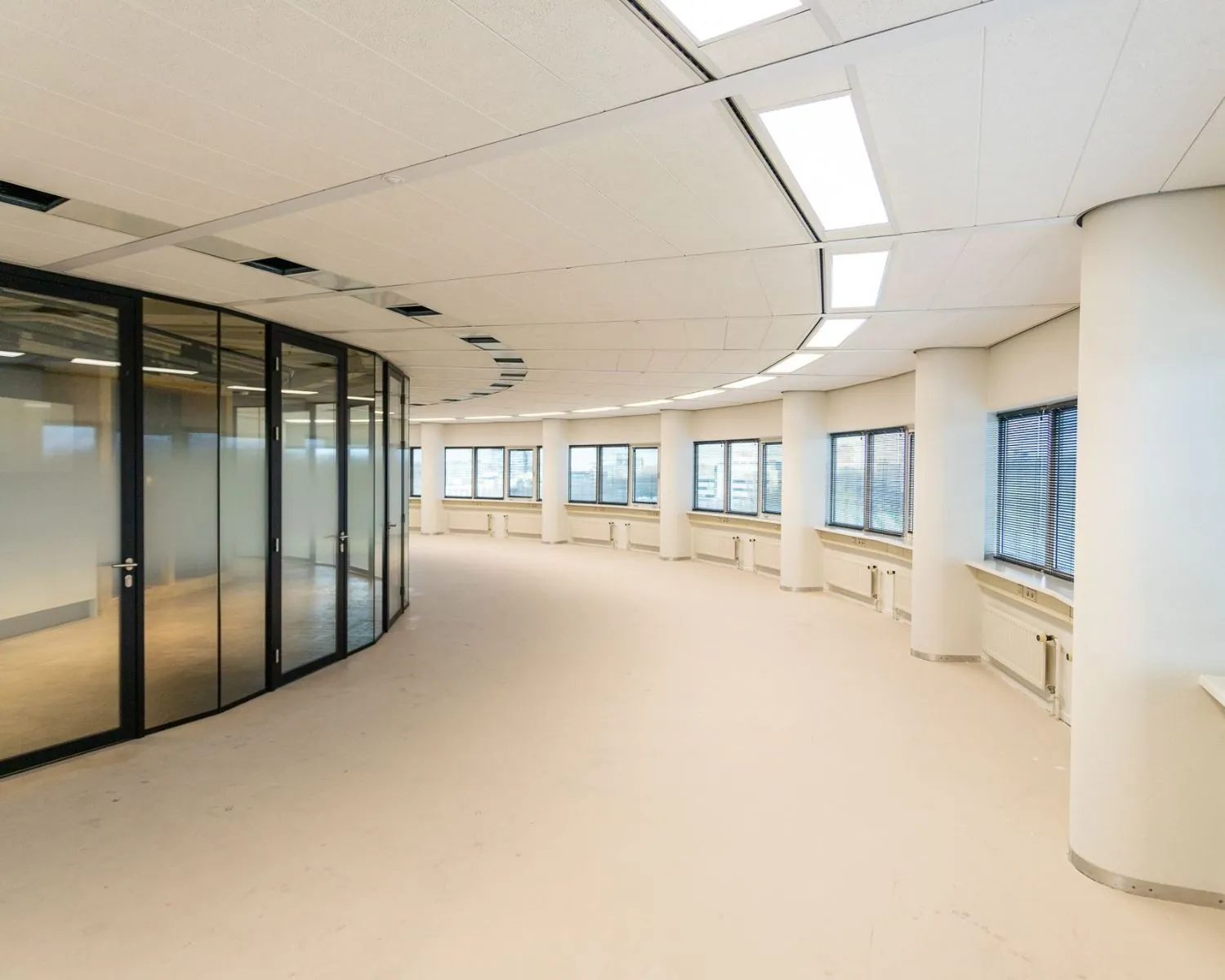 Moderne, lichte kantoorruimte met gebogen glazen vergaderruimte aan de Boerhaavelaan 26.