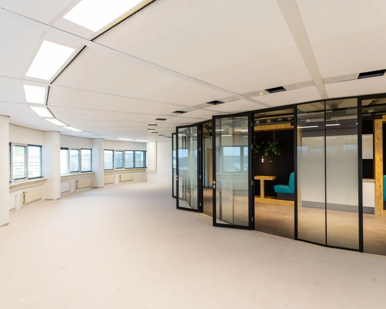 Moderne, lichte kantoorruimte te huur aan de Boerhaavelaan 26 met glazen vergaderruimtes en uitzicht naar buiten.