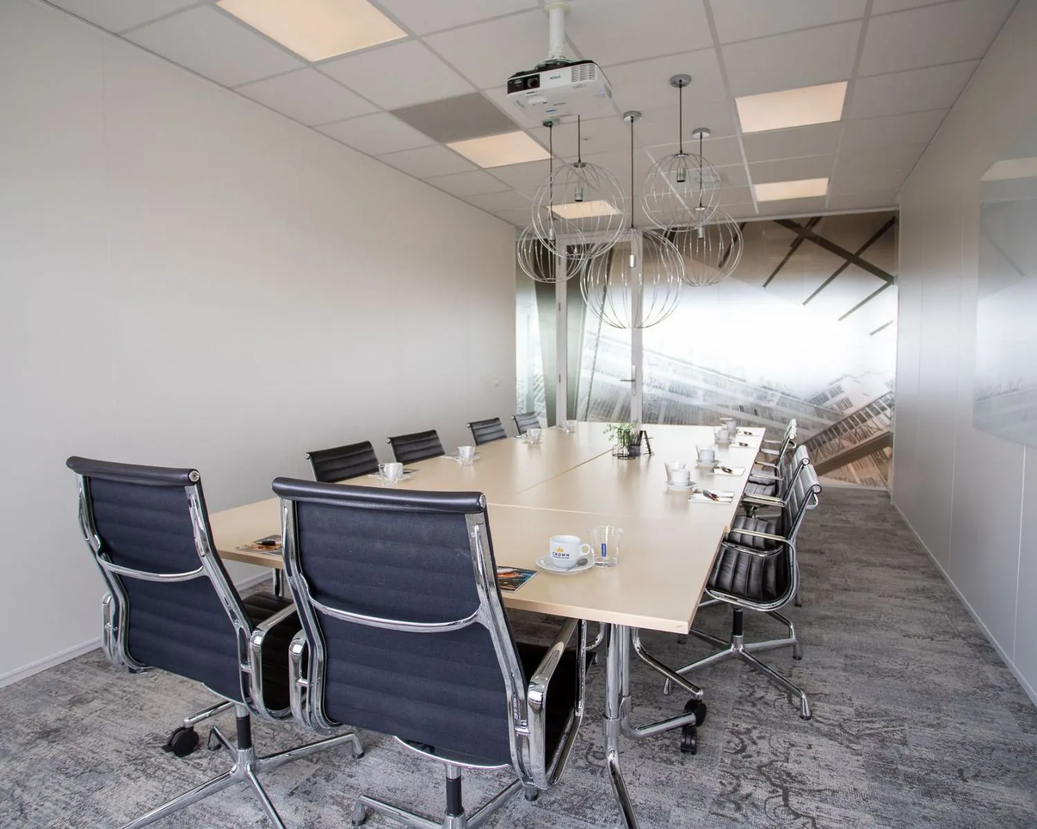 Moderne vergaderruimte met lange tafel, zwarte stoelen en plafondverlichting in kantoor aan de Boerhaavelaan 26.