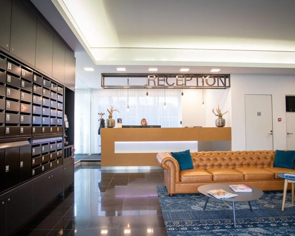 Moderne ontvangstruimte met receptiebalie, leren bank, postvakkenwand en decoratieve elementen in een kantoorgebouw aan de Boerhaavelaan 40.