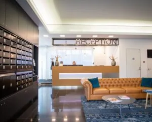 Moderne ontvangstruimte met receptiebalie, leren bank, postvakkenwand en decoratieve elementen in een kantoorgebouw aan de Boerhaavelaan 40.
