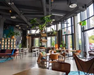 Moderne, lichte kantoorruimte aan de Boerhaavelaan 40 met een industriële inrichting, veel planten en grote ramen.