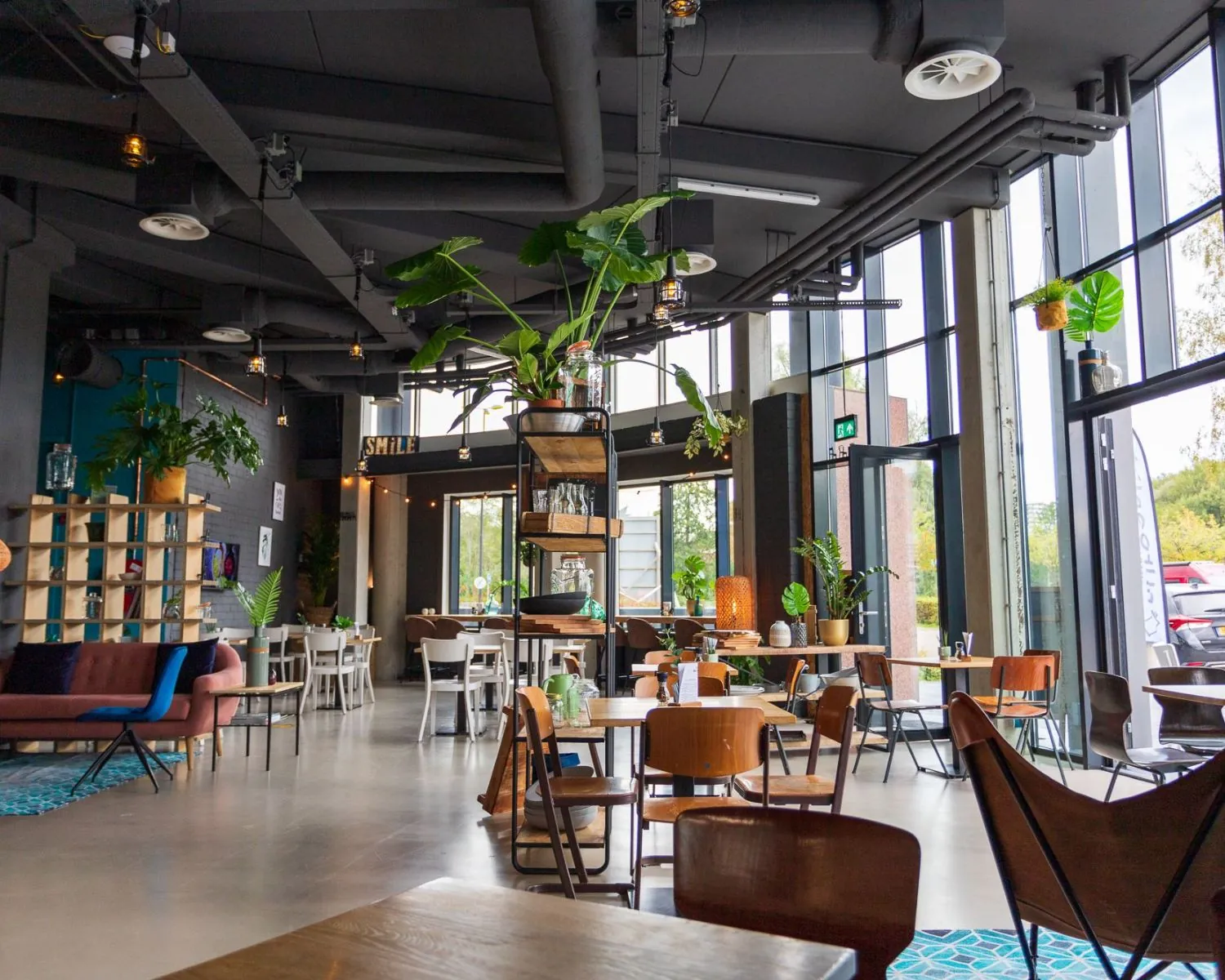 Moderne, lichte kantoorruimte aan de Boerhaavelaan 40 met een industriële inrichting, veel planten en grote ramen.