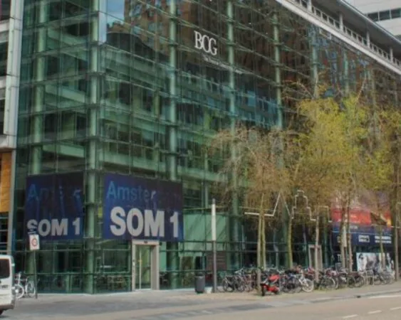 Glazen kantoorgebouw aan de Claude Debussylaan 7 in Amsterdam met BCG-logo en fietsen geparkeerd langs de straat.