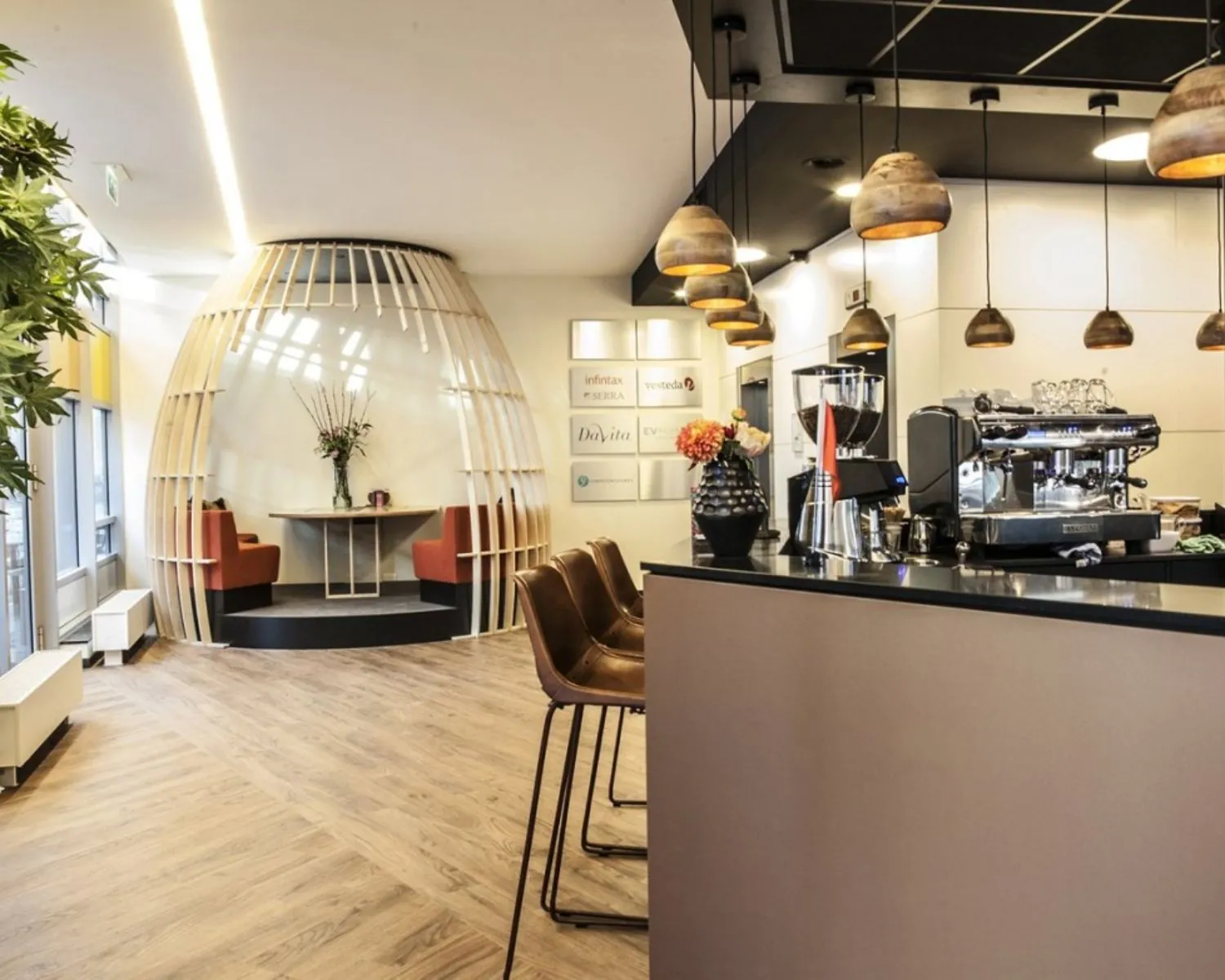 Moderne kantoorruimte aan de Claude Debussylaan met koffiebalie, zithoek en stijlvolle houten inrichting.