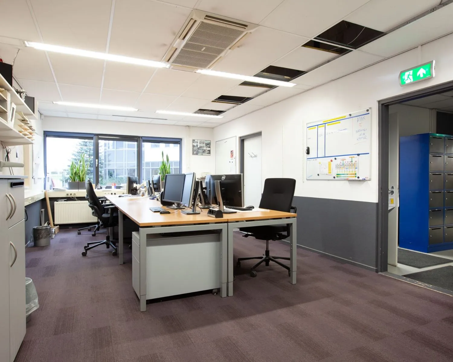 Moderne kantoorruimte met meerdere bureaus, computers en ergonomische bureaustoelen aan de Coenecoop 7-5.