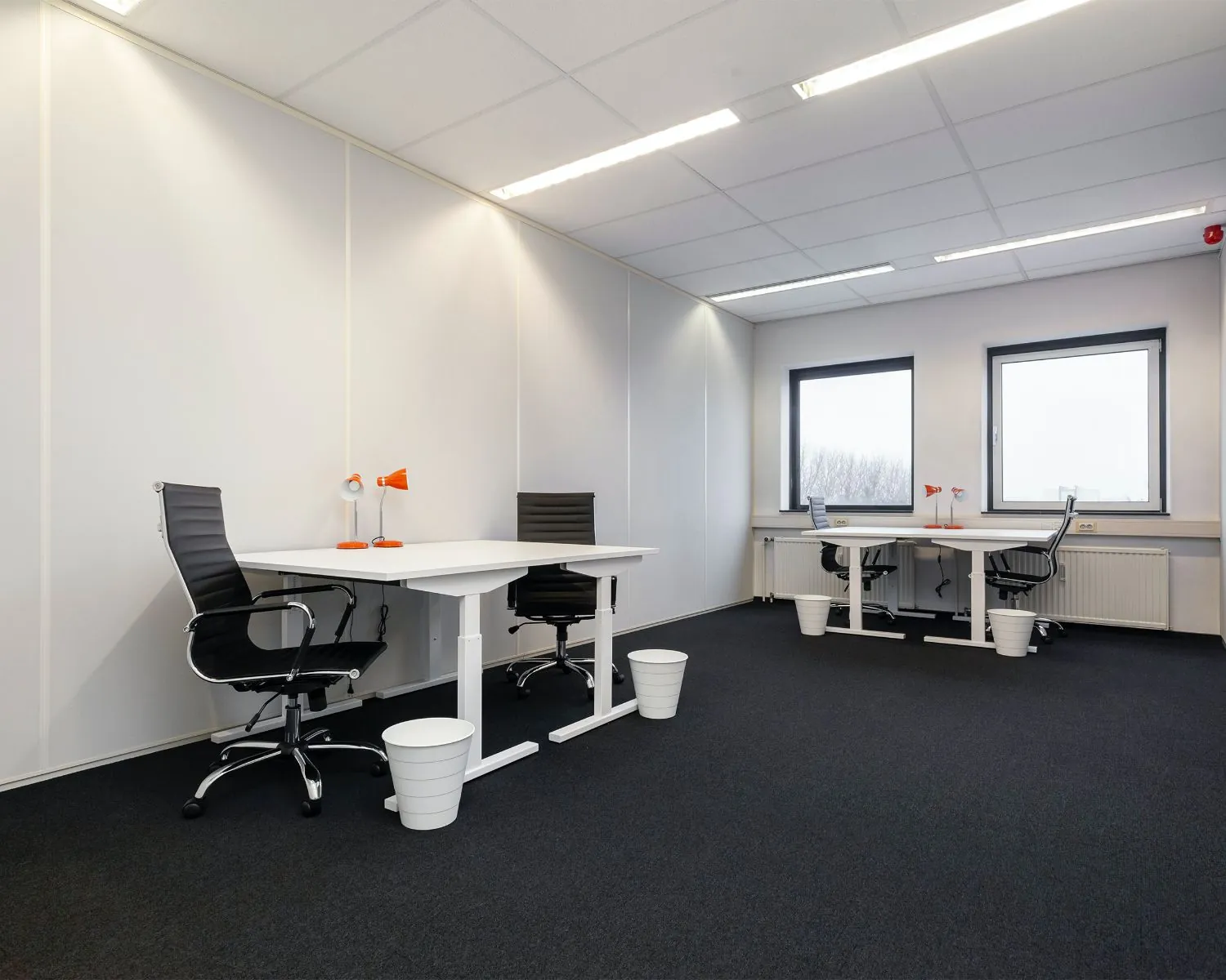 Moderne, lichte kantoorruimte met vier bureaus en zwarte bureaustoelen aan de Corkstraat 46 in Rotterdam.