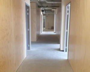 Gang met houten wanden en meerdere kantoorruimtes in kantoorpand aan de Cypresbaan 3-4.