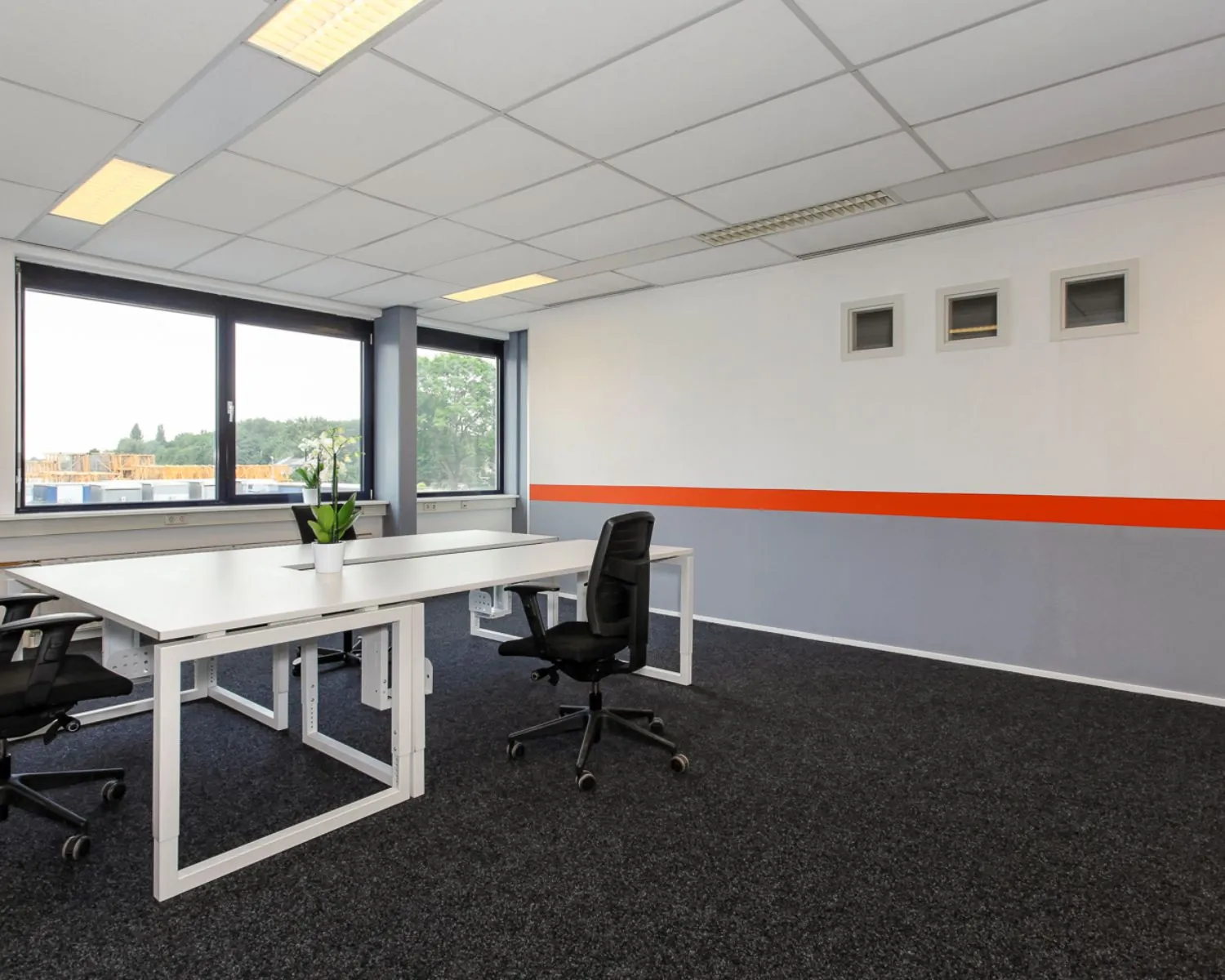 Moderne kantoorruimte met bureaus, bureaustoelen en grote ramen aan De Limiet 15 in Vianen.