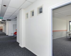 Lichte kantoorruimte aan De Limiet 15 in Vianen met grijze vloerbedekking en deels wit plafond.