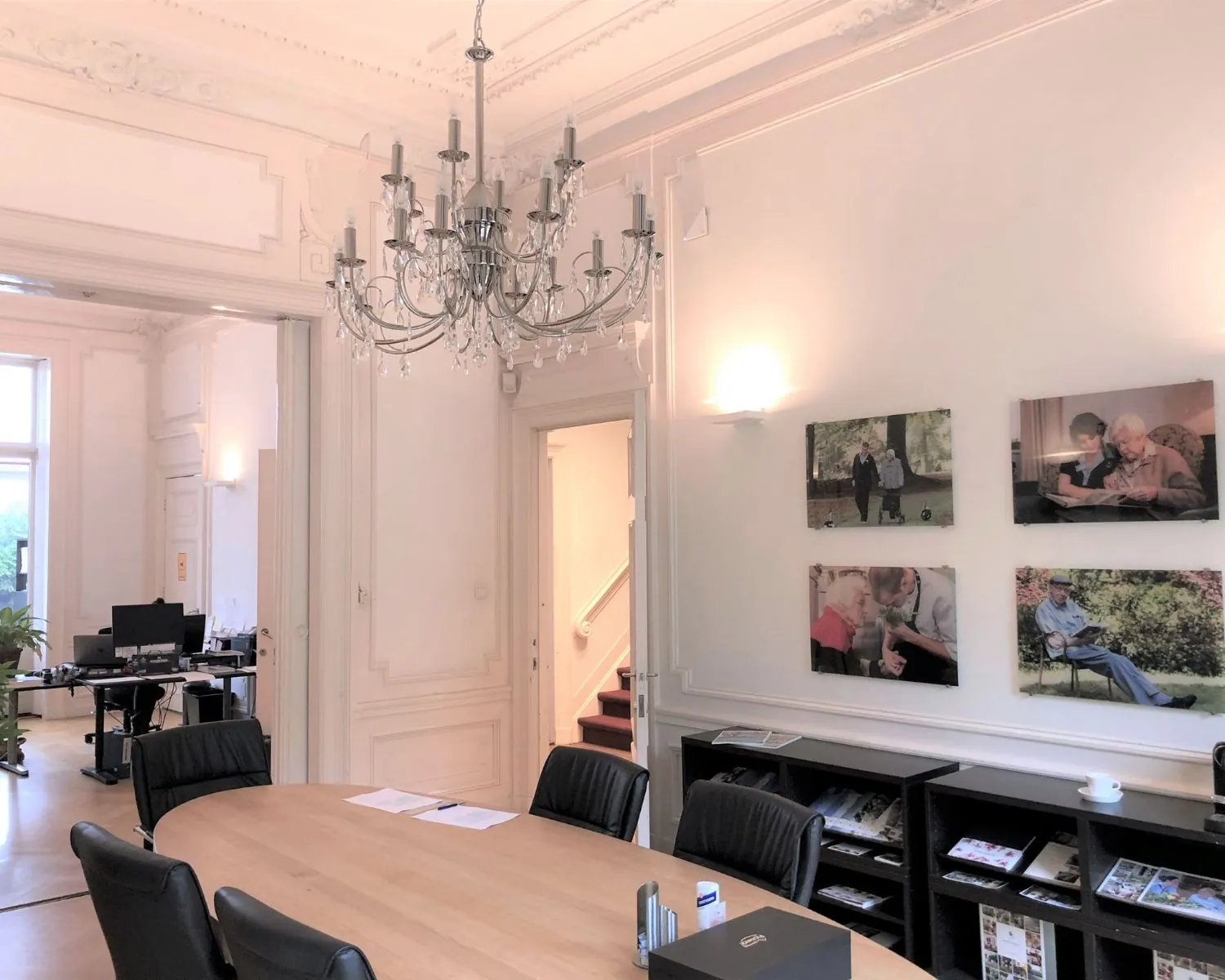 Vergaderruimte in een klassiek kantoor met hoge plafonds, een kroonluchter en foto's aan de muur aan de Dreef 36 in Haarlem.