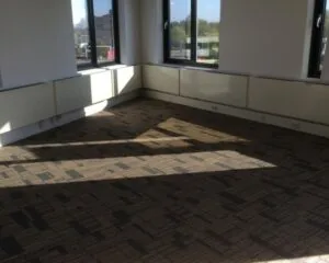 Lichte, lege kantoorruimte met tapijtvloer en grote ramen aan de Essebaan 13.