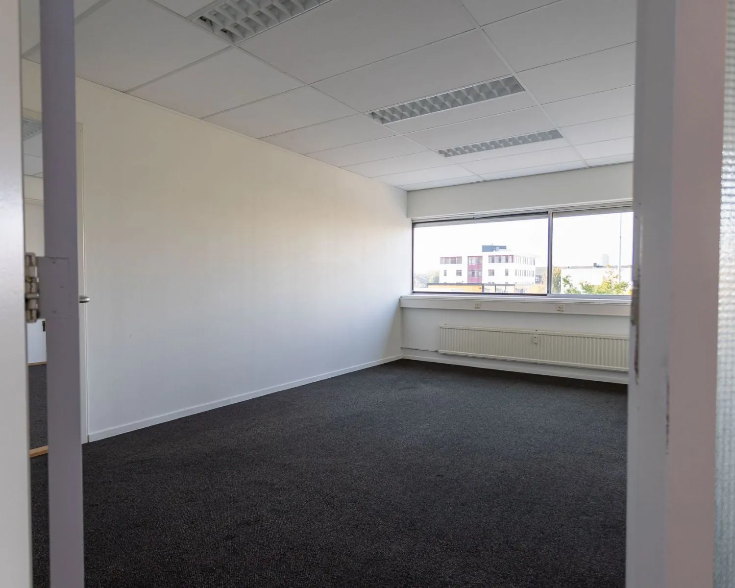 Leegstaand kantoor met raam en systeemplafond aan de Fruitweg 16-30.