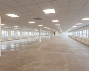 Lege, ruime kantoorruimte met systeemplafond en grote raampartijen aan de Groeneweg 2-3.