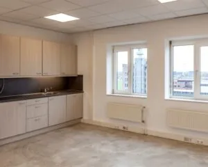 Kantoorruimte met keukenblok en uitzicht op de Groeneweg in een modern kantoorgebouw.