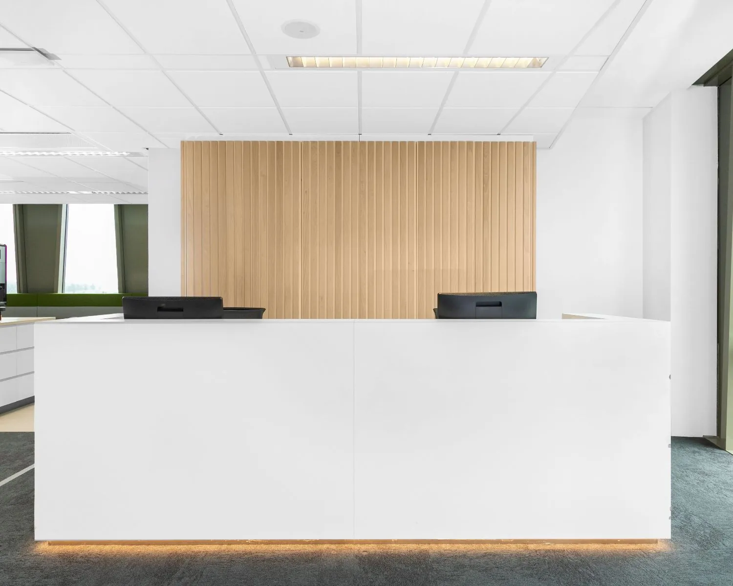 Moderne witte receptiebalie met houtaccenten in een kantoorruimte aan de Grote Voort 293a in Zwolle.