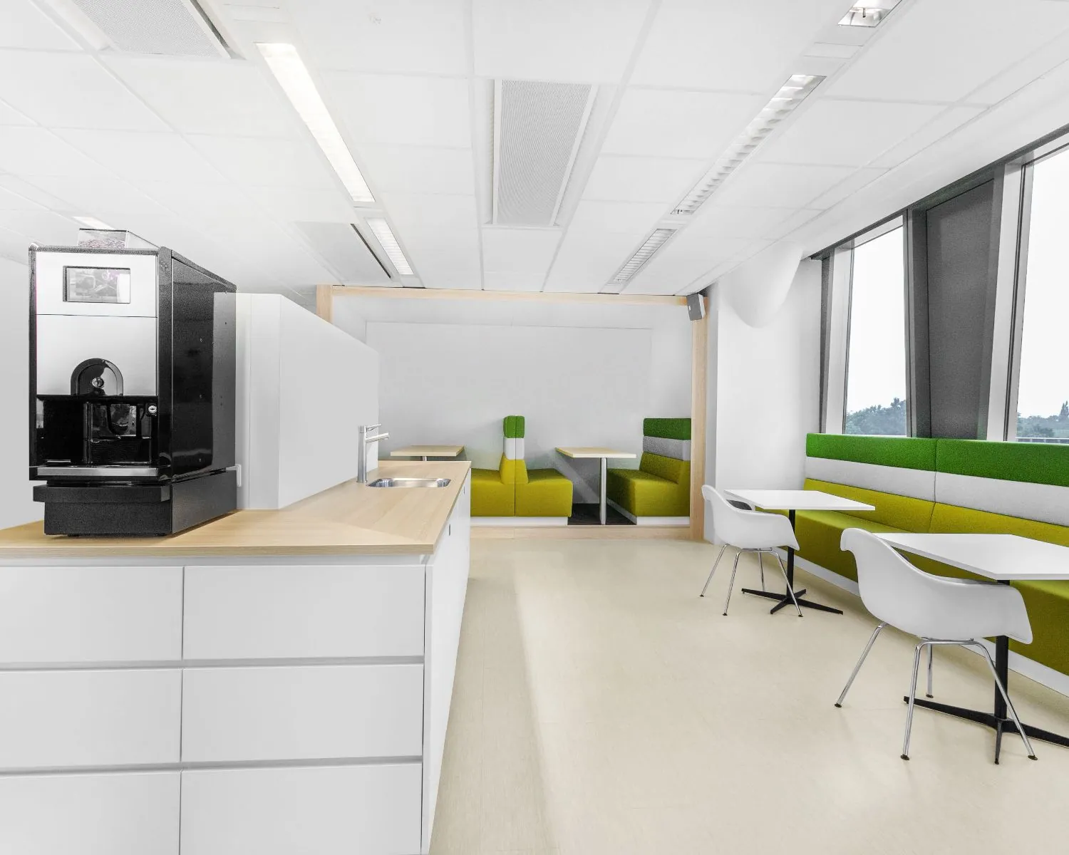 Moderne, lichte kantoorruimte met koffiemachine, zithoeken en grote ramen aan de Grote Voort 293a in Zwolle.