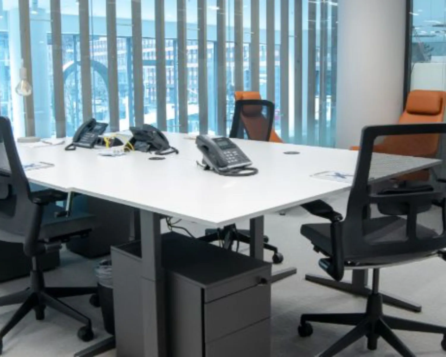 Moderne kantoorruimte met vergadertafel, bureaustoelen en telefoons aan het Gustav Mahlerplein in Amsterdam.