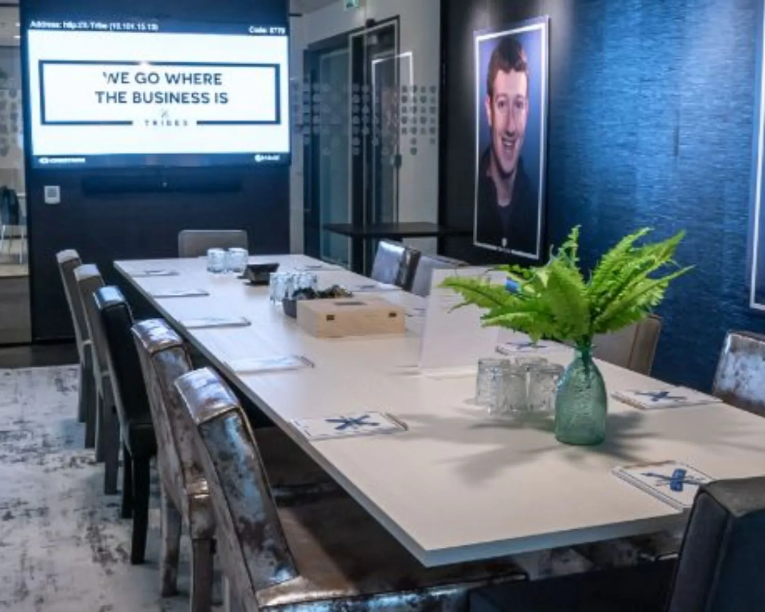 Moderne vergaderruimte met lange tafel, stoelen, presentatiescherm en decoratieve plant in een kantoorpand aan het Gustav Mahlerplein 28 in Amsterdam.