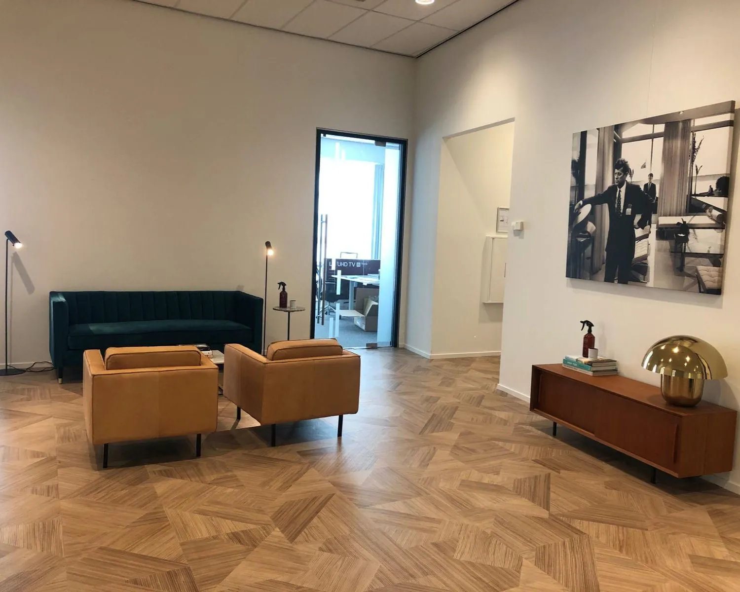 Moderne wachtruimte in kantoor aan de HJE Wenckebachweg 123 in Amsterdam met stijlvolle meubels en houten vloer.