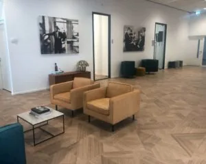 Moderne en stijlvolle wachtruimte in een kantoor aan de H.J.E. Wenckebachweg 123 in Amsterdam, met zitmeubilair en kunst aan de muur.