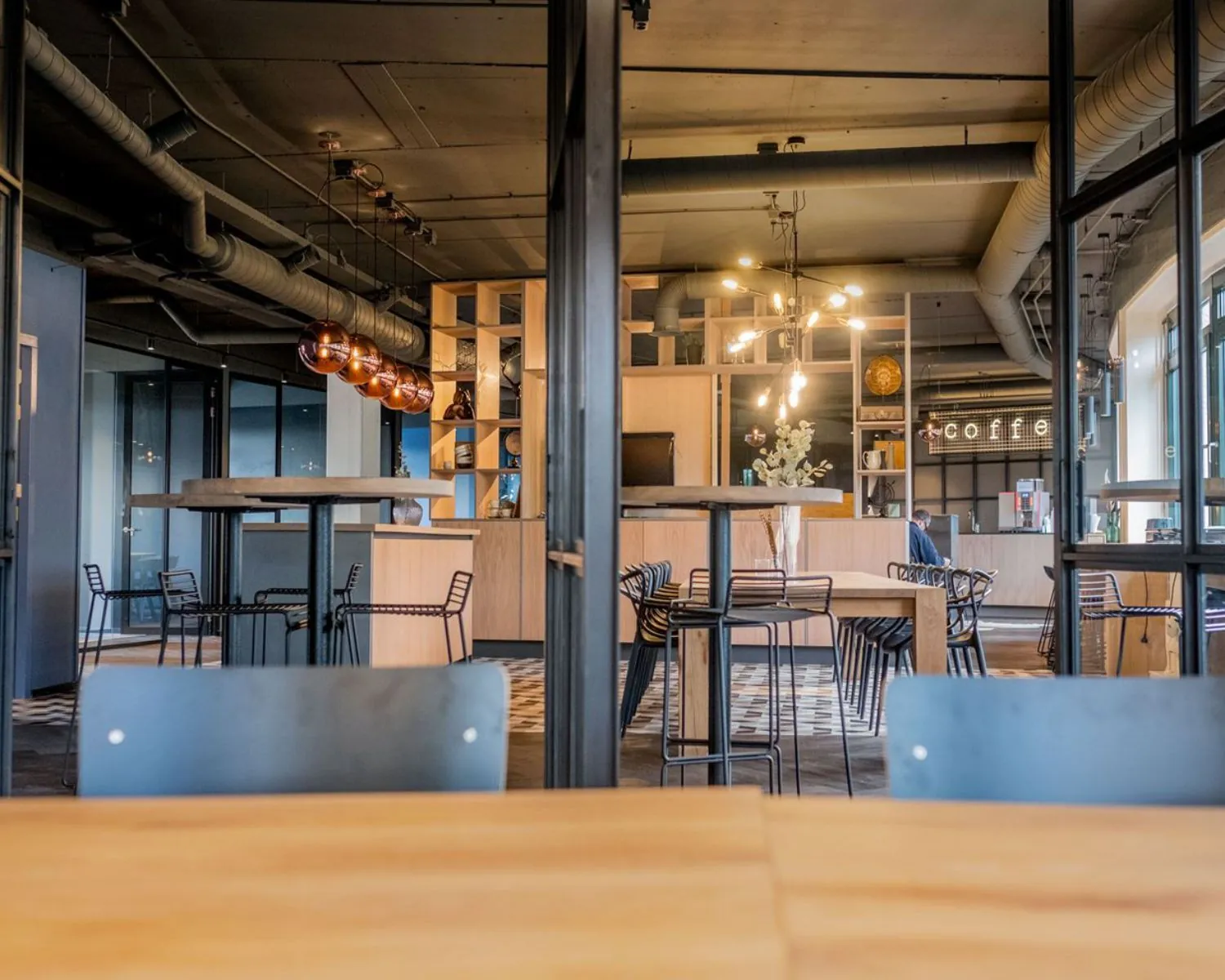 Moderne kantoorruimte met open indeling, houten meubels en een koffiebar aan de Hanzelaan 351 in Zwolle.