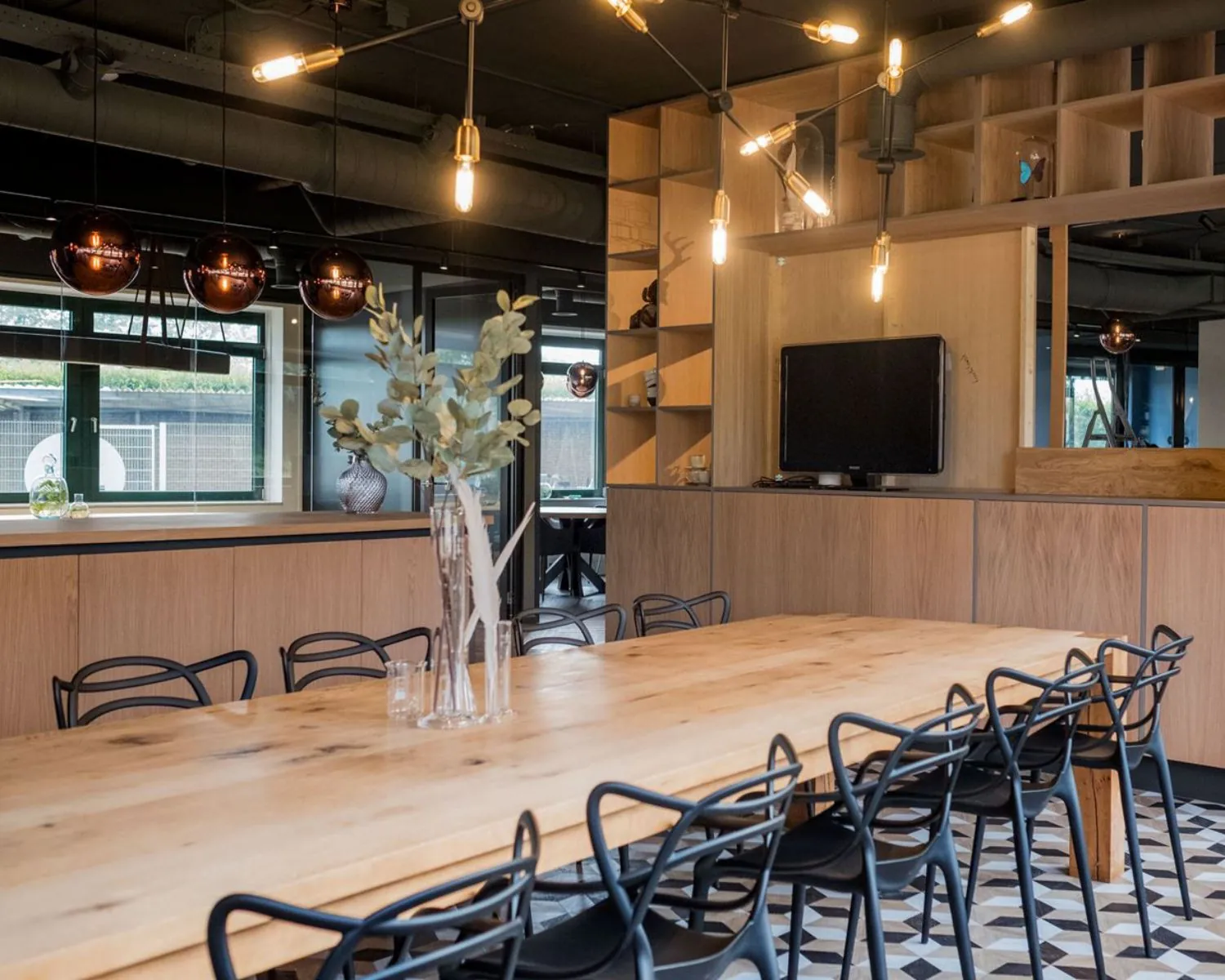 Moderne kantoorruimte aan de Hanzelaan 351 in Zwolle met een lange houten vergadertafel, designstoelen en sfeervolle verlichting.