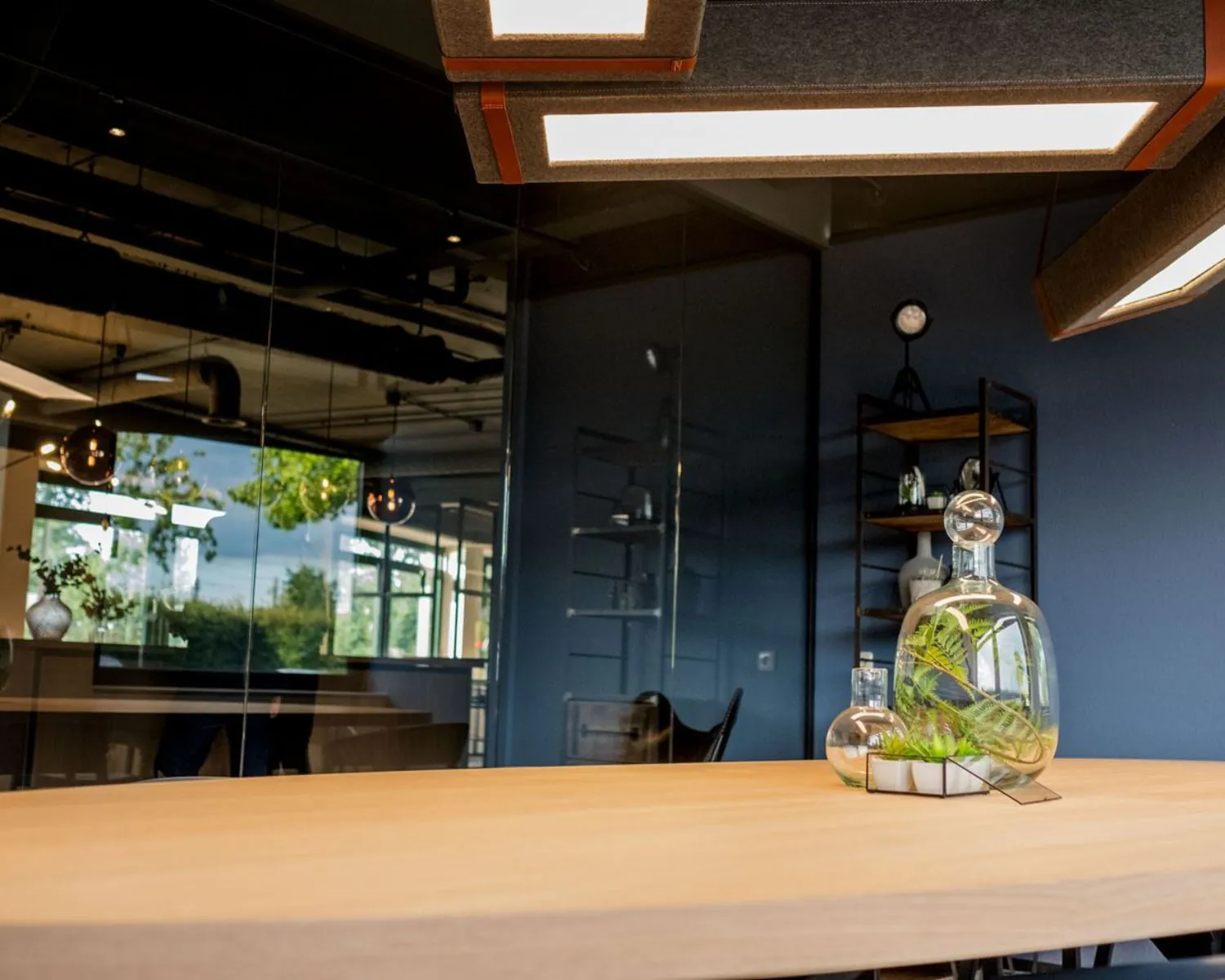 Moderne kantoorruimte aan de Hanzelaan 351 in Zwolle met houten tafel, glazen plantenornamenten en stijlvolle verlichting.