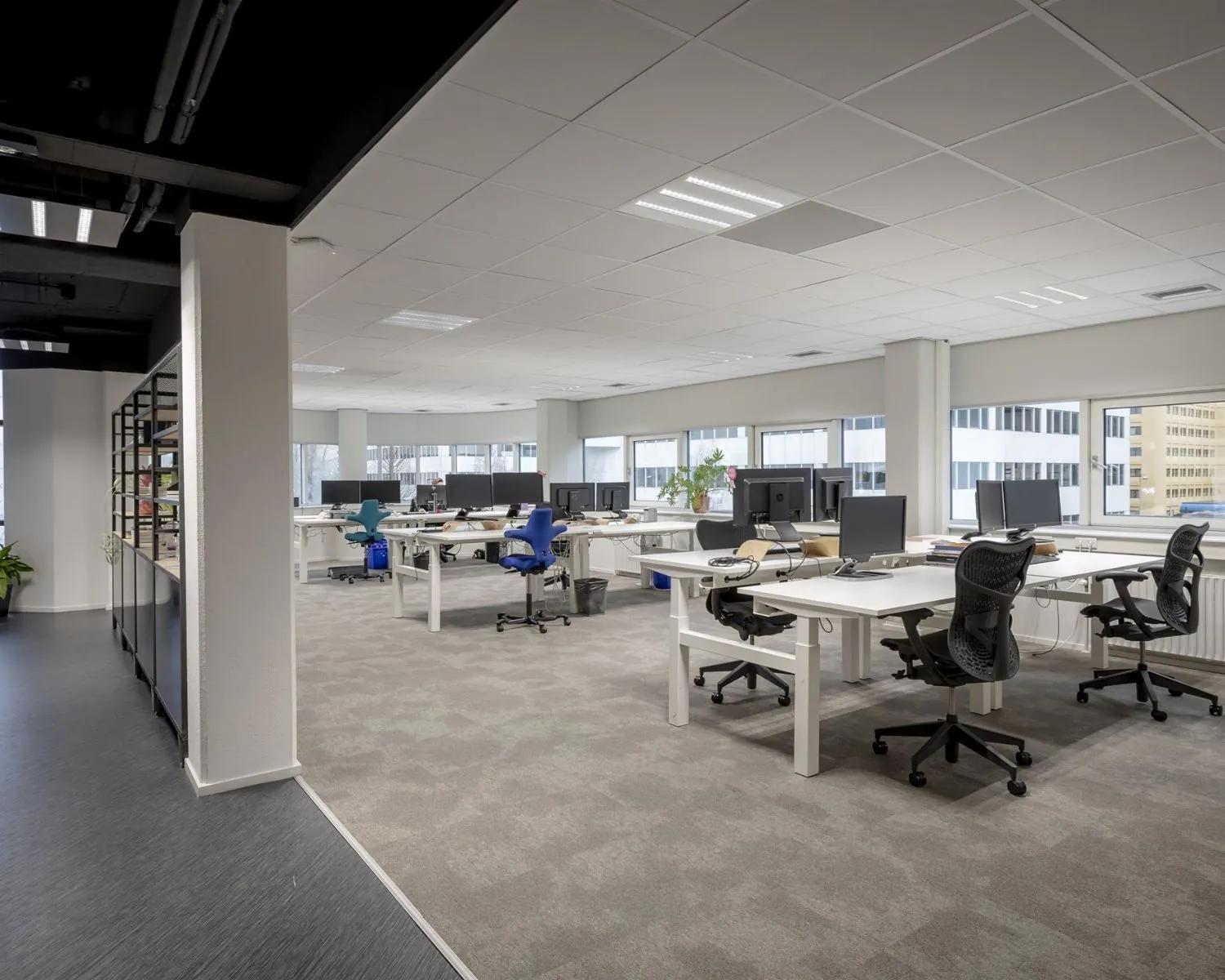 Moderne en lichte kantoorruimte met meerdere bureaus en werkplekken aan de Hogehilweg 8 in Amsterdam.