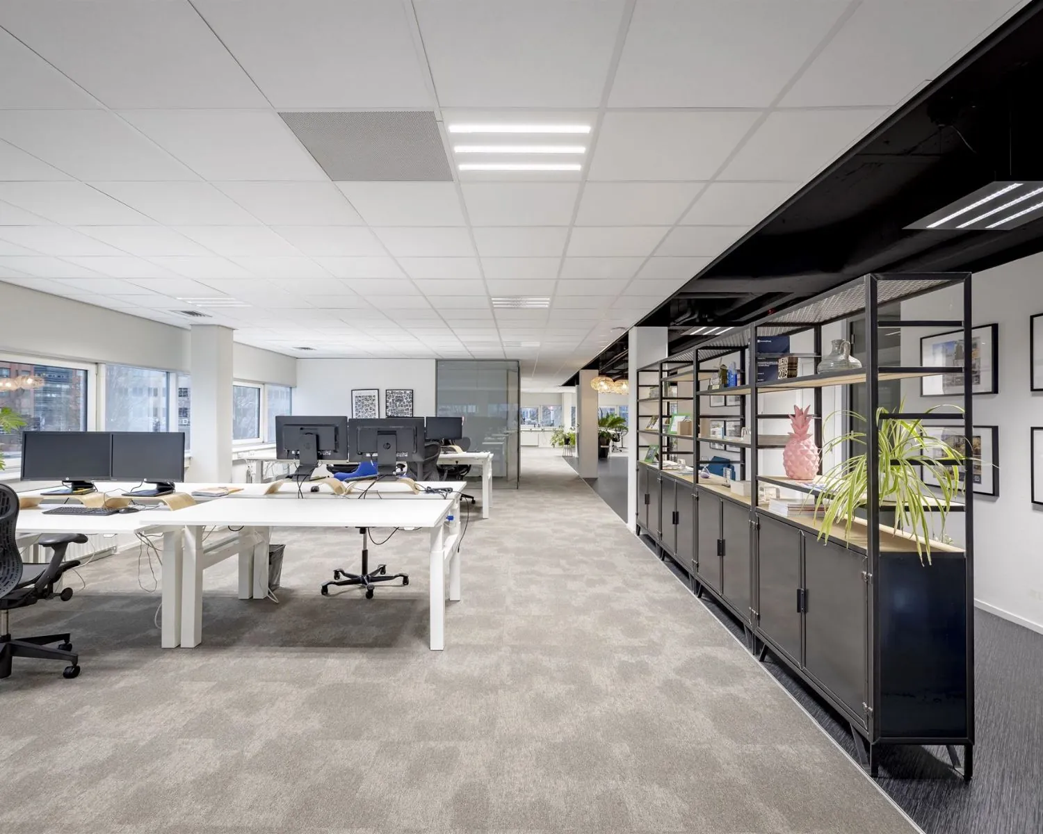 Moderne, ruime kantoorruimte met werkplekken en open kasten aan de Hogehilweg 8.