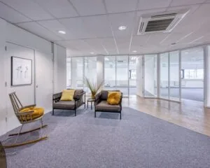 Moderne kantoorruimte met loungehoek en glazen scheidingswanden aan de Hullenbergweg 4 in Amsterdam.