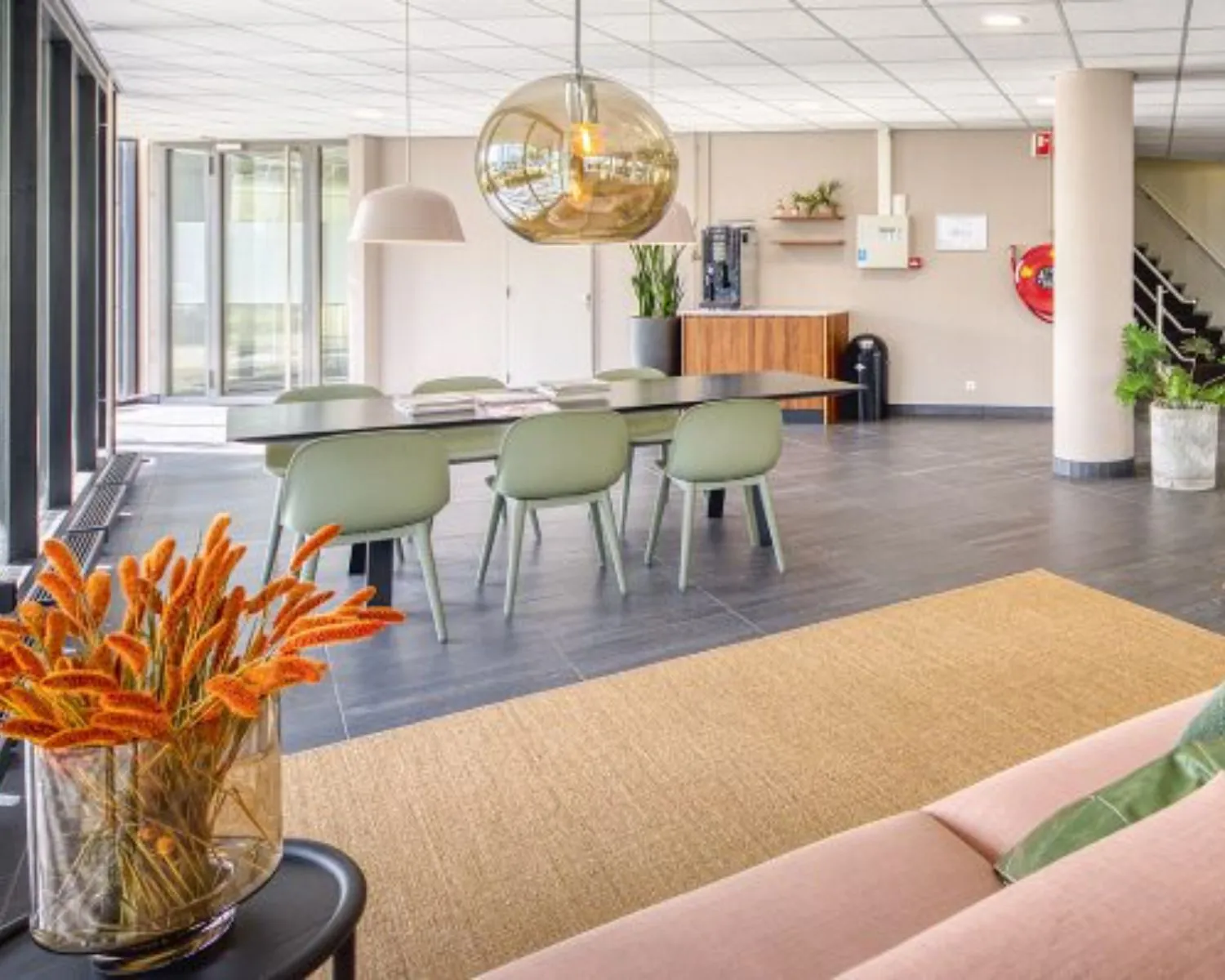 Moderne kantoorruimte aan de Hullenbergweg in Amsterdam met vergadertafel, stijlvolle verlichting en een koffiehoek.