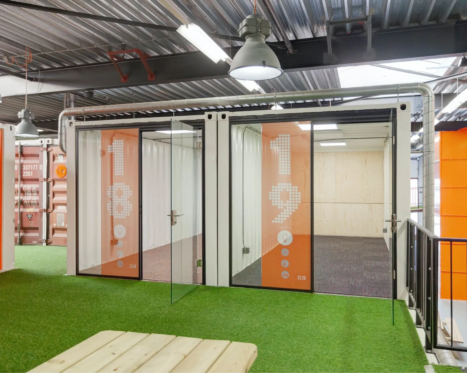 Moderne kantoorruimte in Houten met units 18 en 19, ingericht in een industriële stijl met kunstgrasvloer en glazen deuren.