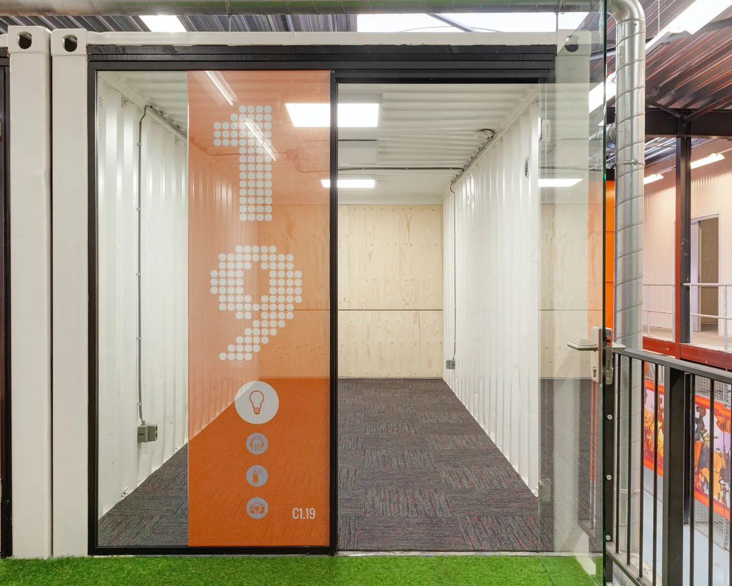 Moderne kantoorruimte te huur in Hoofdveste 2 in Houten, gelegen in een containerunit met glazen deur en oranje gevel met het nummer C1.19.