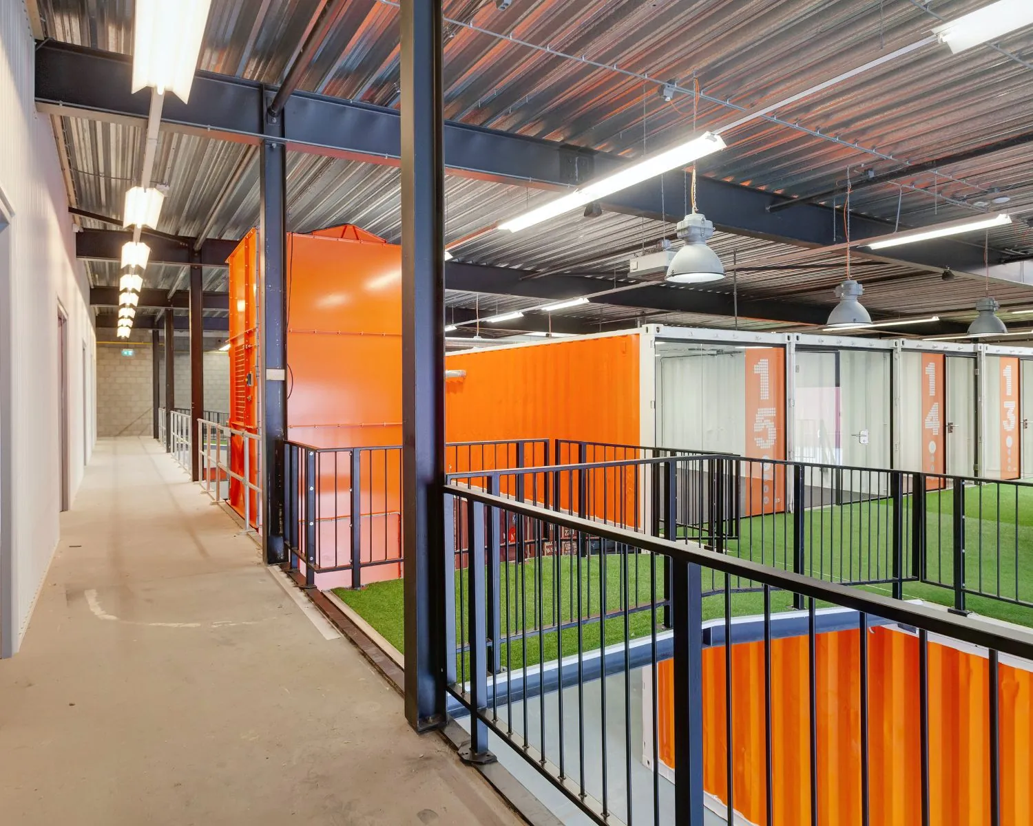 Moderne kantoorruimte in Hoofdveste 2 te Houten met units in feloranje zeecontainers en kunstgrasvloeren.